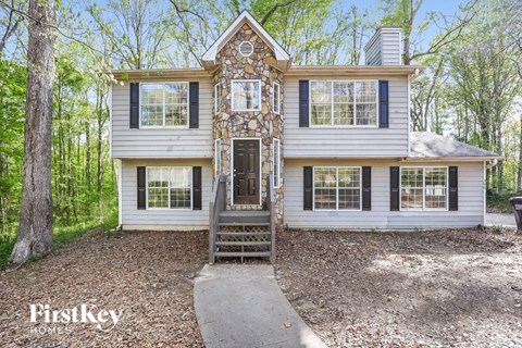 a white and blue house with a front porch and a driveway