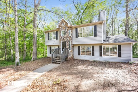 the front of a house with a driveway and a deck
