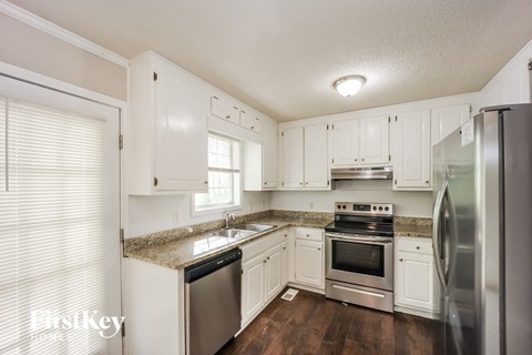 a kitchen with white cabinets and stainless steel appliances