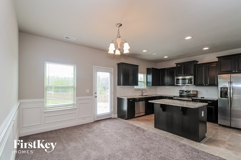 A kitchen with black cabinets and a large island.