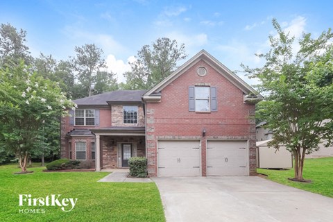 A brick house with a garage is for sale.