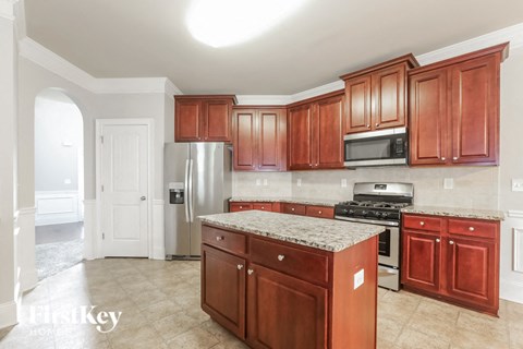 A kitchen with wooden cabinets and a granite counter top.