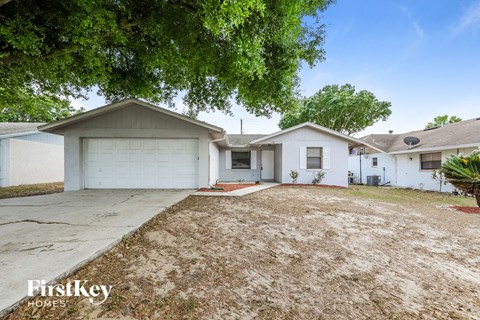 A white house with a garage is for sale.