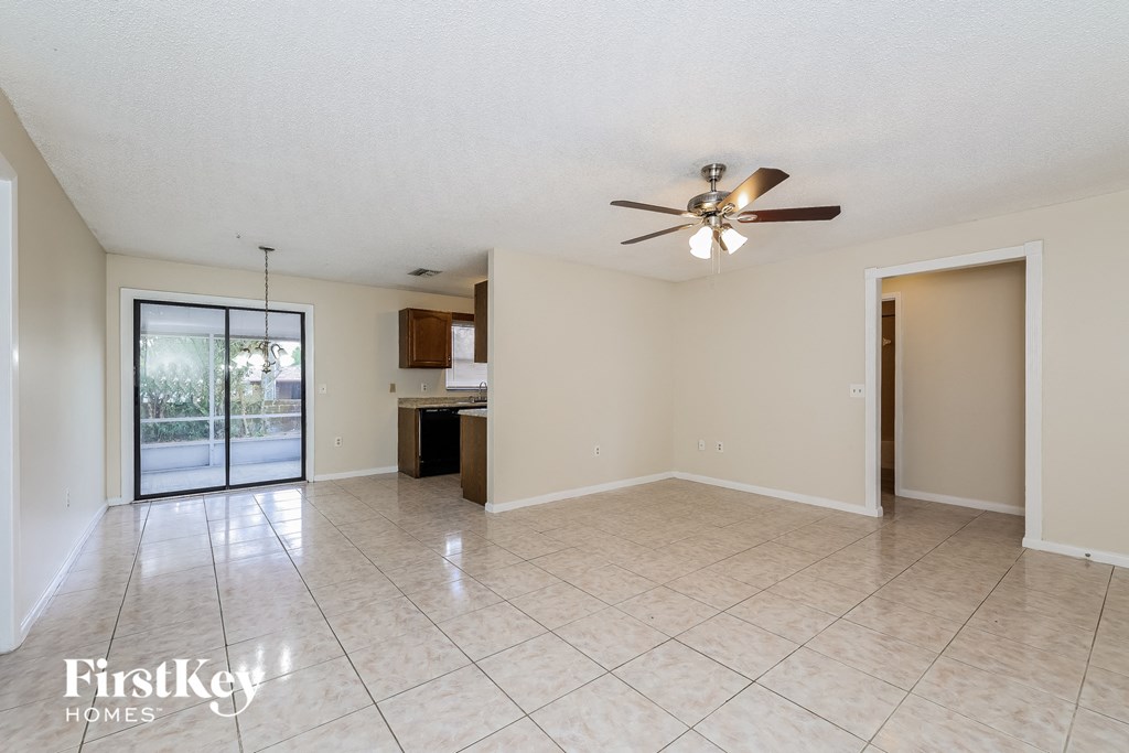 A spacious room with a ceiling fan and tiled flooring.