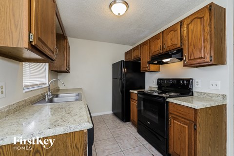 A kitchen with wooden cabinets and black appliances.