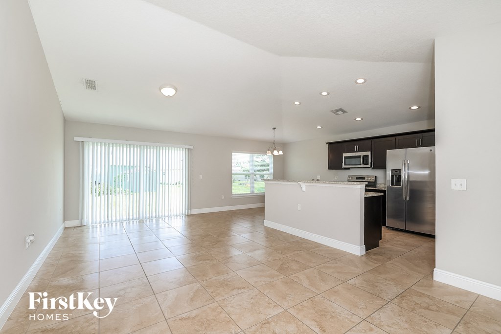 A spacious kitchen with a refrigerator, microwave, and oven.