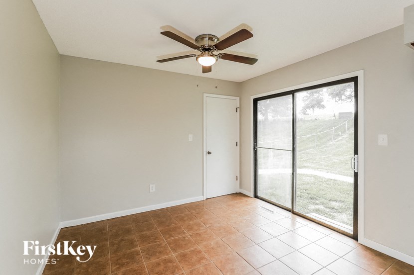 a living room with a ceiling fan and a sliding glass door