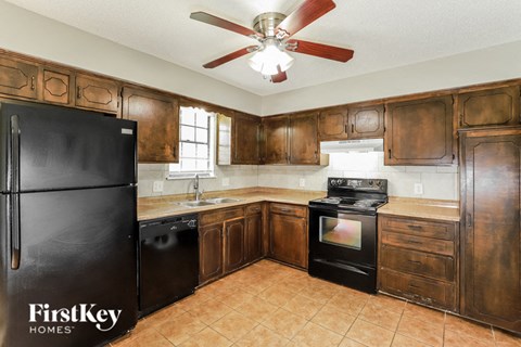 a kitchen with wooden cabinets and a black refrigerator