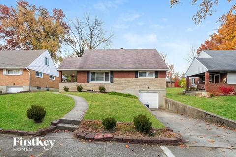 a brick house with a sidewalk in front of it