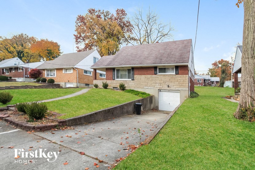 a brick house with a white garage and a sidewalk