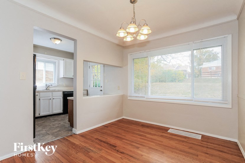an empty living room and kitchen with a large window