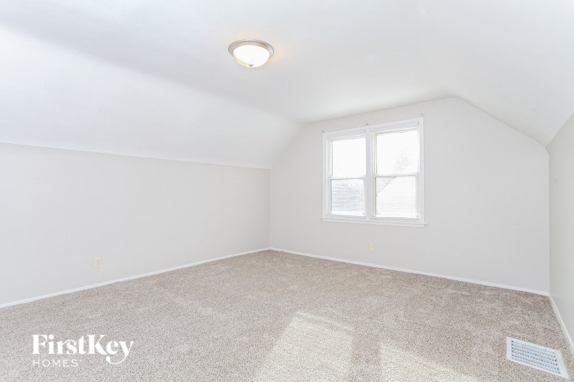 a white room with a window and a carpet