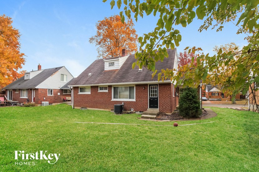 a brick house with a yard and a tree