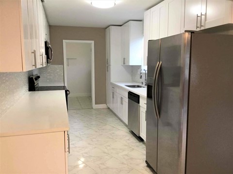 A kitchen with a refrigerator on the right.