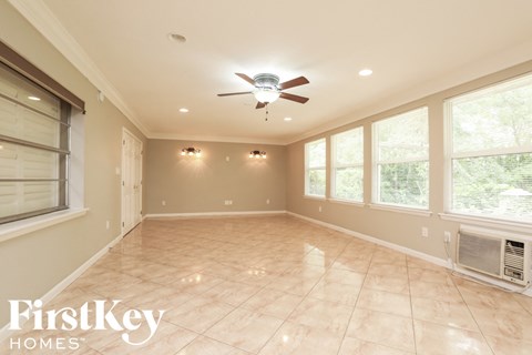 A spacious room with a ceiling fan and tiled flooring.
