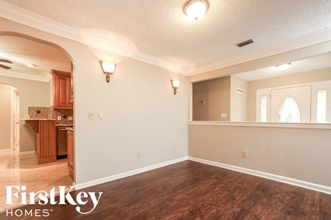 A room with wooden floors and a FirstKey Homes logo.