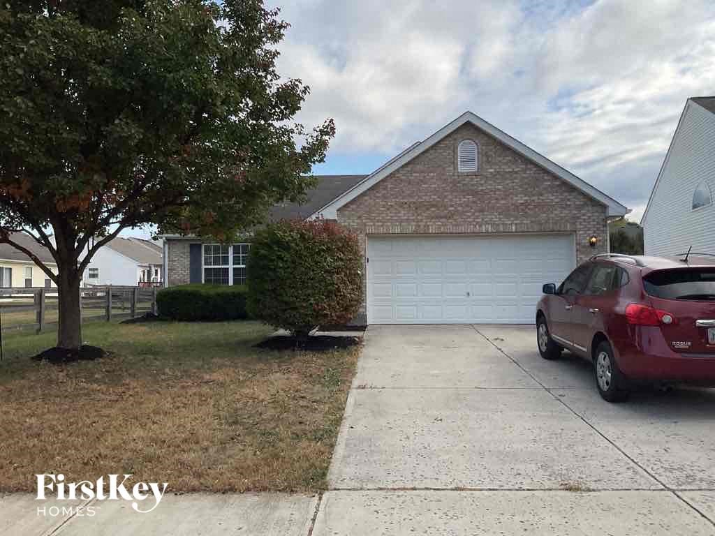 A red car is parked in front of a garage.