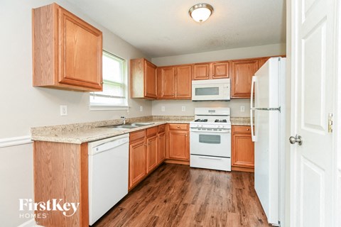 A kitchen with wooden cabinets and white appliances.