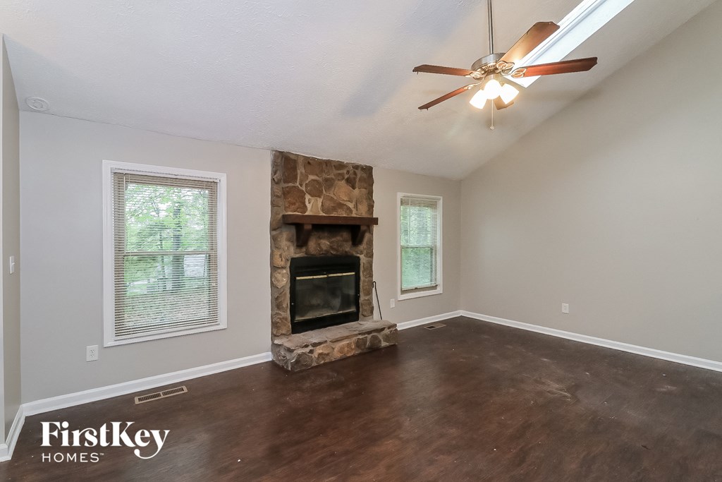 A room with a fireplace and a ceiling fan.