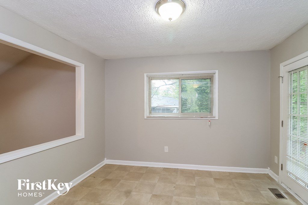 A room with a window and a tiled floor.