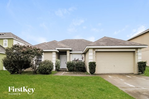 a home with a lawn and a garage door