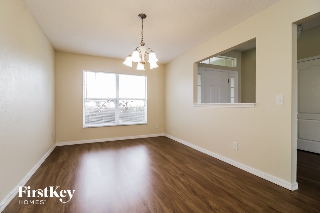 an empty living room with wood flooring and a window