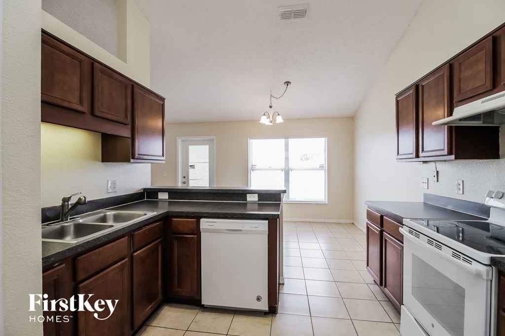 a kitchen with wooden cabinets and a white dishwasher and a sink