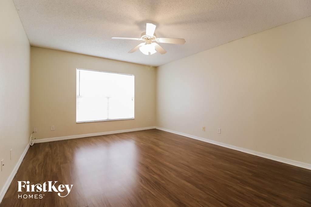 a bedroom with hardwood flooring and a ceiling fan