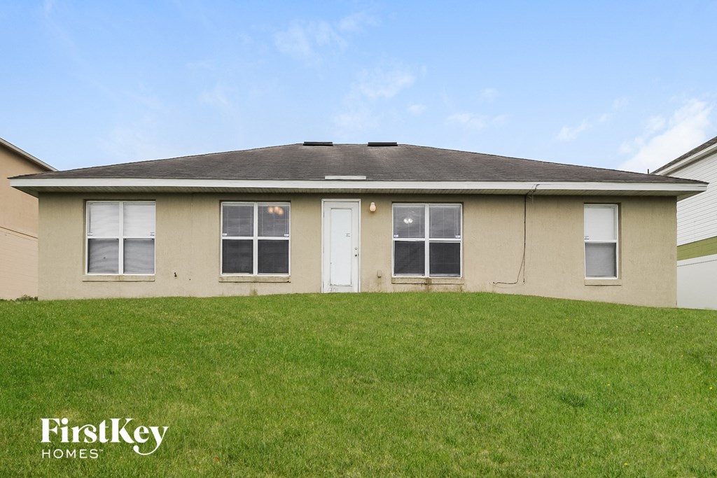 the backyard of a house with a lawn and a white door