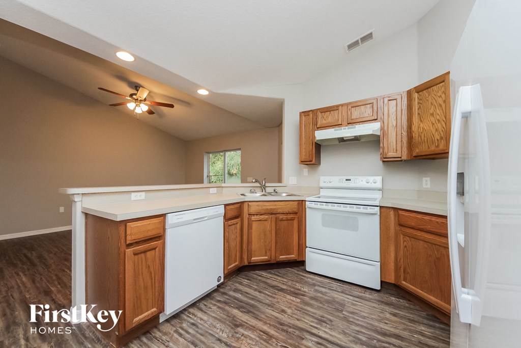 A kitchen with wooden cabinets and a white dishwasher.