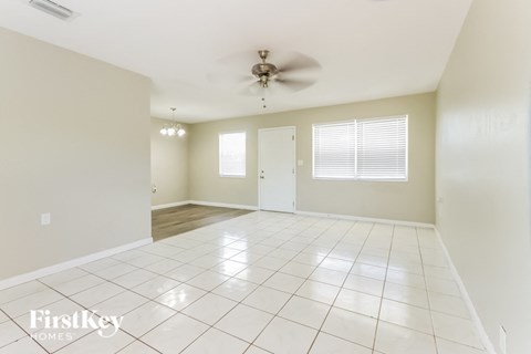 A spacious room with a ceiling fan and tile flooring.