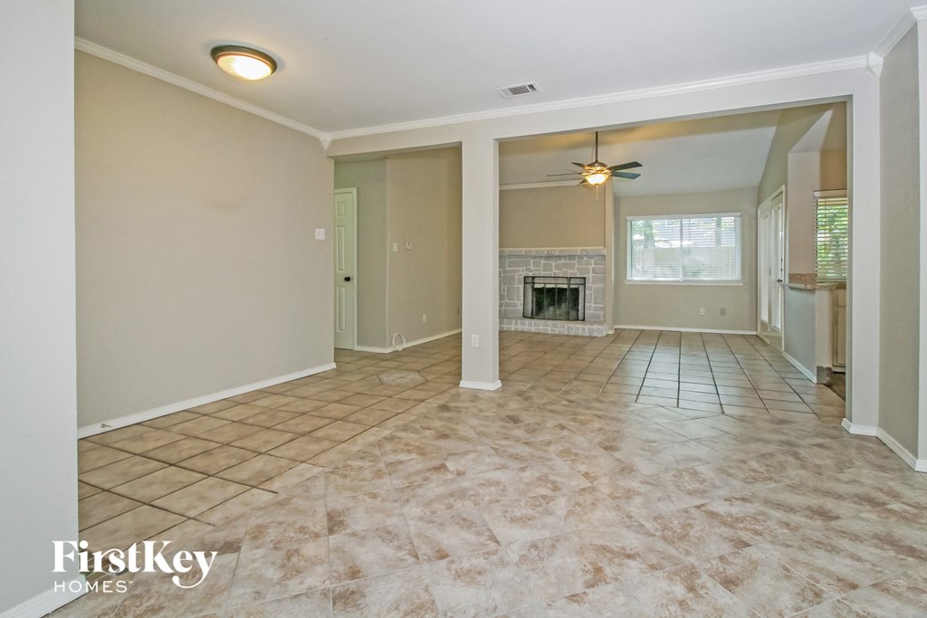 an empty living room with a fireplace and tile flooring