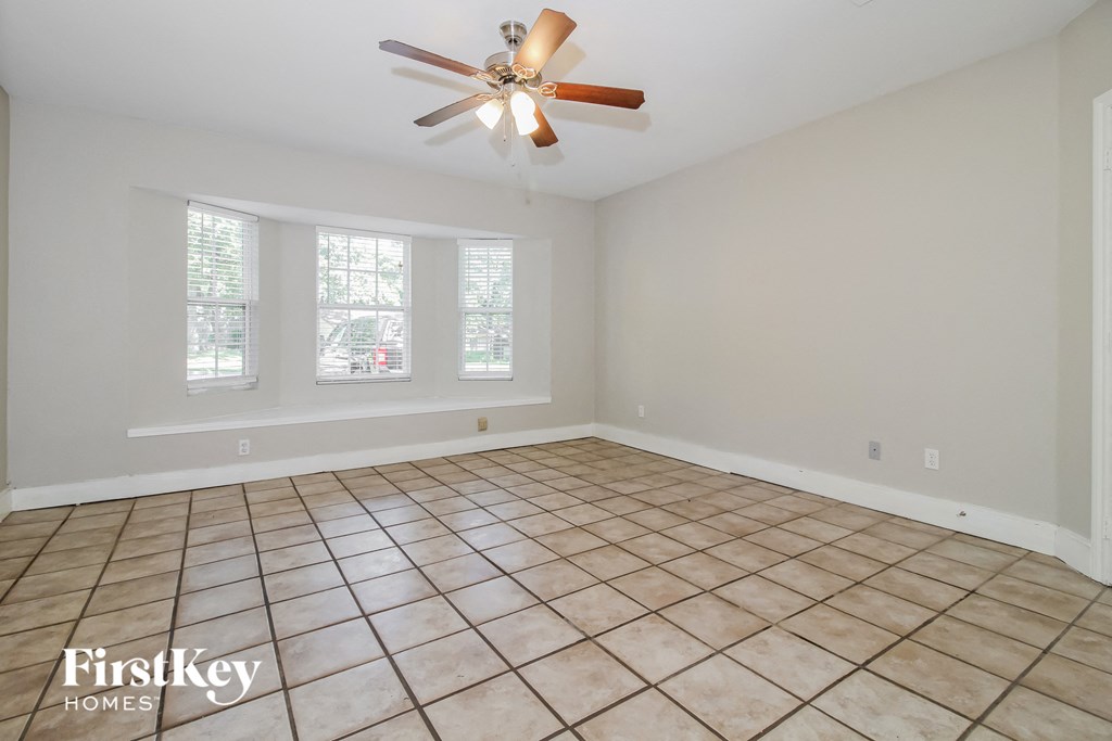 the living room of an empty house with a ceiling fan