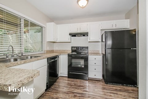 a kitchen with black appliances and white cabinets