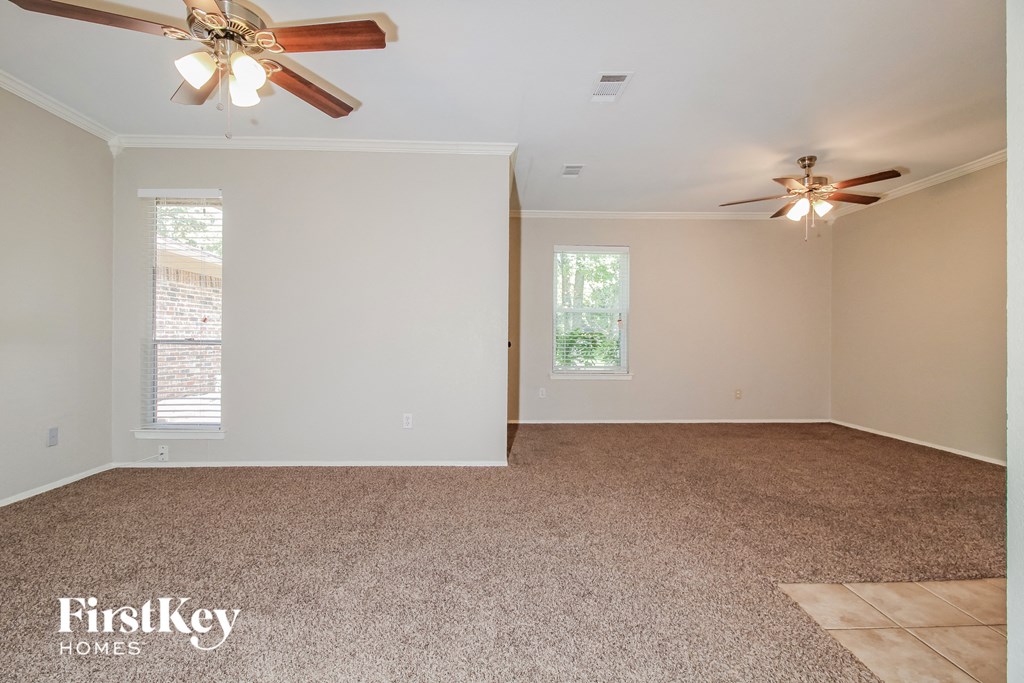 the living room of an empty house with a ceiling fan