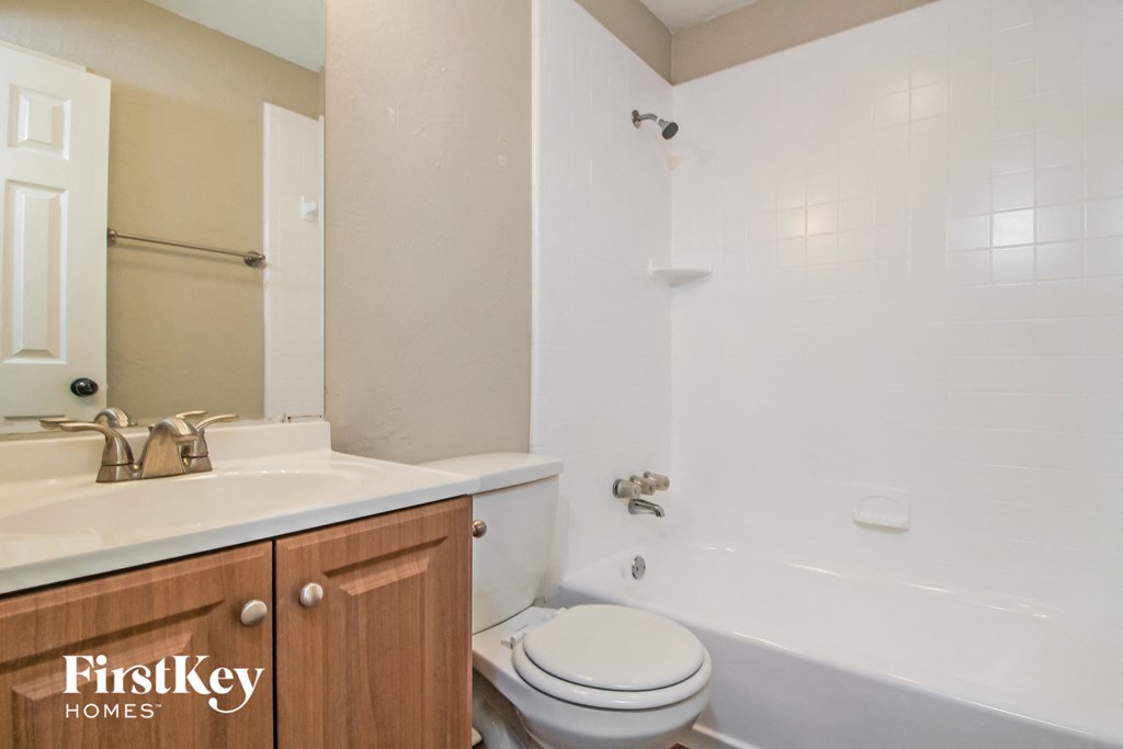 a bathroom with a toilet and a sink and a bath tub