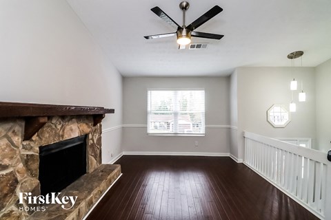 a living room with a fireplace and a ceiling fan