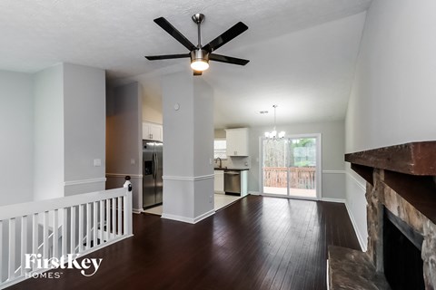 a living room with a staircase and a ceiling fan