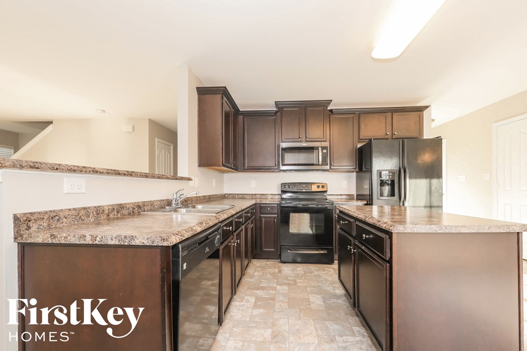 A kitchen with brown cabinets and a granite countertop.