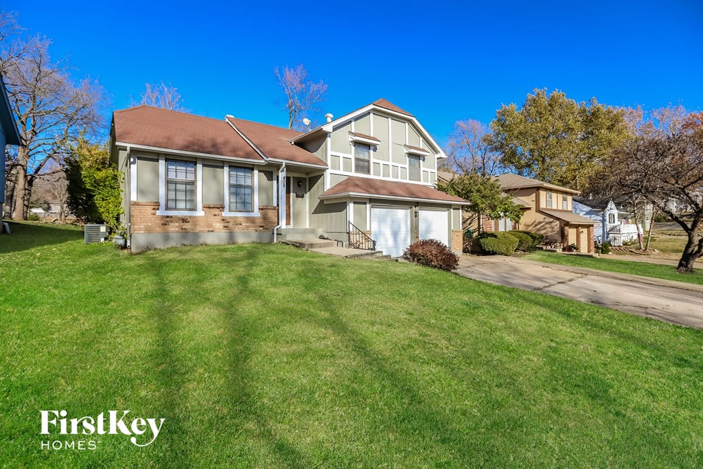 a home with a green lawn and a blue sky