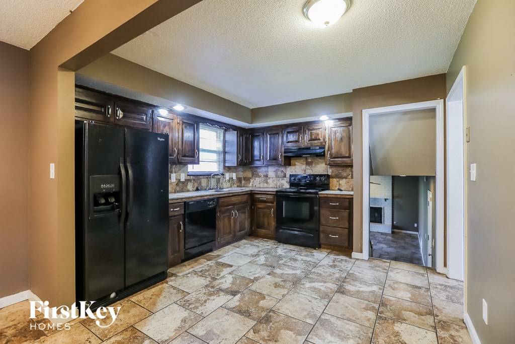 the kitchen has a large center island and black appliances