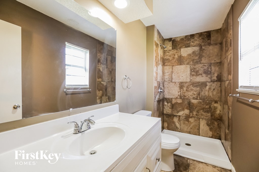 a bathroom with a white sink and a shower and a toilet
