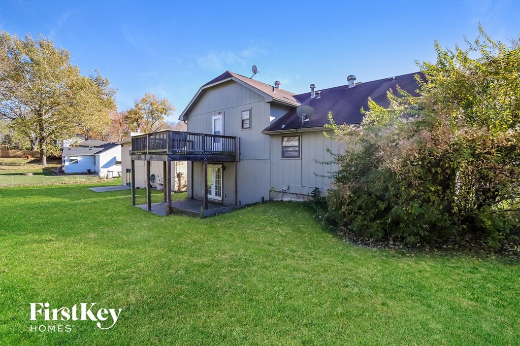 a white house with a backyard and a deck