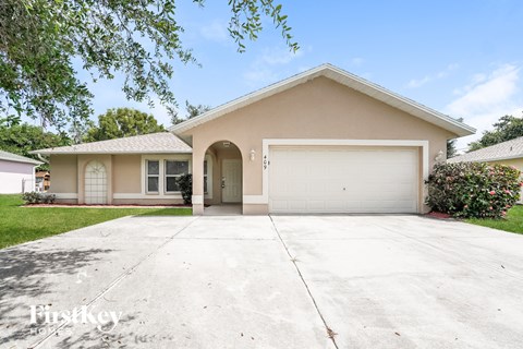 a beige house with a driveway and a white garage door