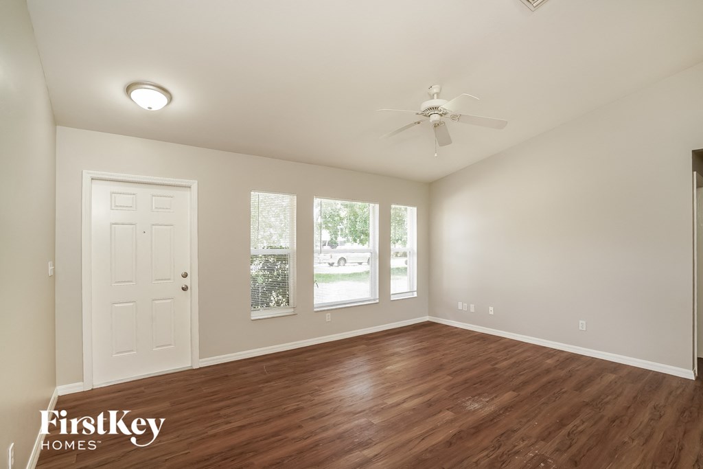 a living room with wood flooring and a ceiling fan