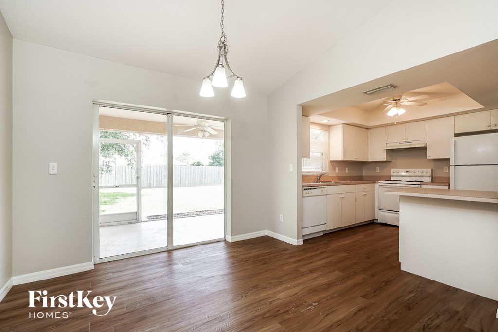 an open kitchen and living room with a sliding glass door to a patio