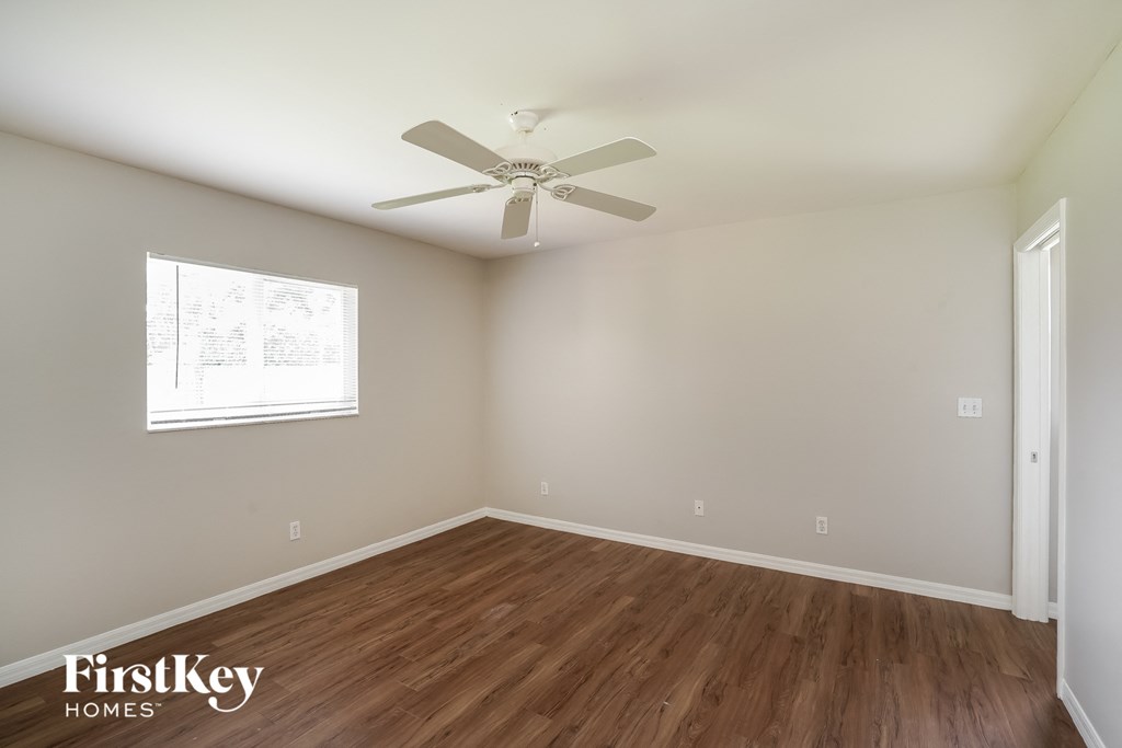 a bedroom with hardwood flooring and a ceiling fan