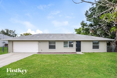 a white house with a grassy yard and a black door