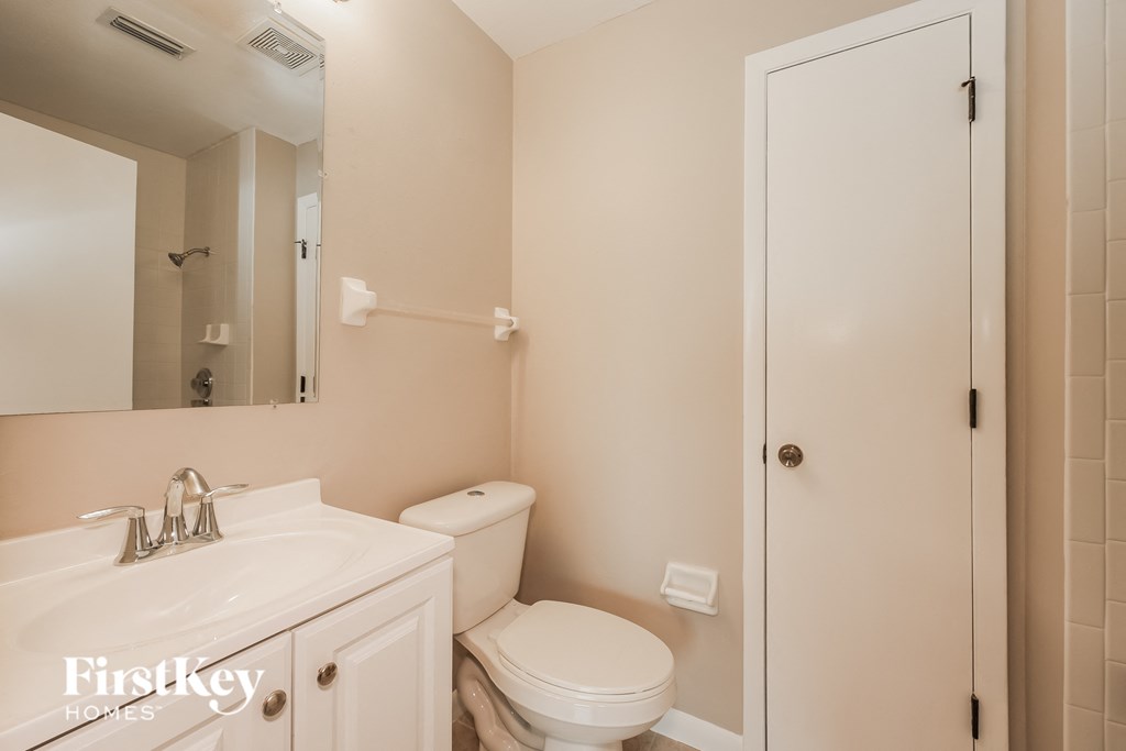a bathroom with a sink toilet and a mirror