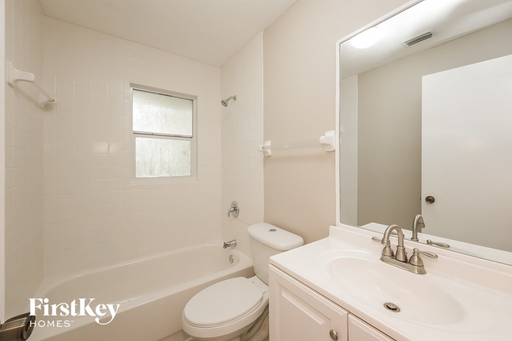 a white bathroom with a sink toilet and tub